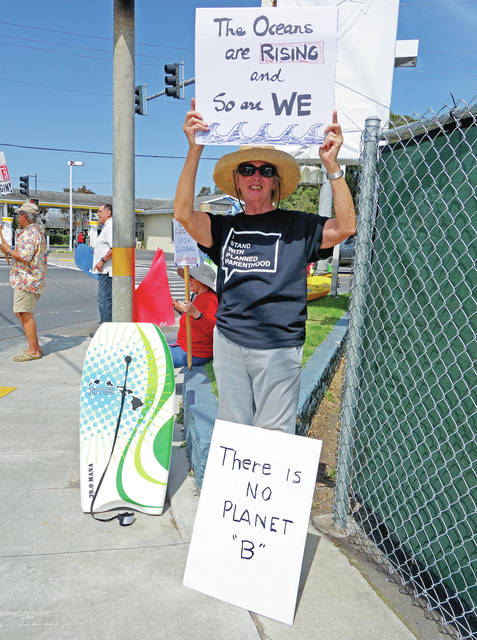 5284023_web1_Resident-Carolyne-Riley-holds-a-sign-in-Waimea-town-center-voicing-her-opinion-on-the-perils-of-climate-change-and-the-effects-it-will-have-close-to-home201742911012193.jpg